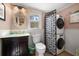 Functional bathroom with a unique vanity, stacked washer/dryer, and decorative mirror at 8403 W Gulf Blvd, Treasure Island, FL 33706