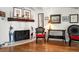 Bright living room with a stone fireplace, wood mantle, and stylish wicker furniture at 8403 W Gulf Blvd, Treasure Island, FL 33706
