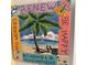 Artistic wall hanging showing a beach scene with a palm tree and the words 