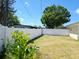 Well-maintained backyard with a pristine white fence and lush green foliage at 8719 Sunlit Cove Ne Dr, St Petersburg, FL 33702