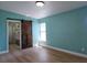 Bedroom with wood floors, barn door to en suite bathroom, and a sunlit window at 8719 Sunlit Cove Ne Dr, St Petersburg, FL 33702