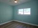 Bright bedroom featuring a ceiling fan, wood floors, and a window offering natural light at 8719 Sunlit Cove Ne Dr, St Petersburg, FL 33702