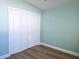 Bedroom featuring hardwood floors, light blue walls and a closet with white doors at 8719 Sunlit Cove Ne Dr, St Petersburg, FL 33702