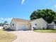 Welcoming single-story home with a brick driveway, attached garage, and beautifully landscaped yard at 8719 Sunlit Cove Ne Dr, St Petersburg, FL 33702