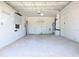 Spacious and unfinished garage with concrete floor, white walls, and a door at 8719 Sunlit Cove Ne Dr, St Petersburg, FL 33702