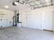 Spacious unfinished garage featuring concrete floor, white walls, and equipment at 8719 Sunlit Cove Ne Dr, St Petersburg, FL 33702