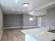 Bright, open-concept living space adjacent to the kitchen area, featuring stylish flooring and neutral wall colors at 8719 Sunlit Cove Ne Dr, St Petersburg, FL 33702
