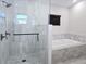 Modern bathroom with a walk-in glass shower, rainfall shower head, and soaking tub at 8719 Sunlit Cove Ne Dr, St Petersburg, FL 33702