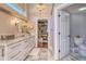 Bathroom featuring double sinks, marble countertops, and a walk-in closet with custom shelving at 898 Cypress Lakeview Ct, Tarpon Springs, FL 34688