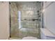 Modern bathroom features marble tiled shower with frameless glass door at 898 Cypress Lakeview Ct, Tarpon Springs, FL 34688