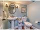 Charming powder room has a pedestal sink, elegant fixtures, and coordinated decor at 898 Cypress Lakeview Ct, Tarpon Springs, FL 34688