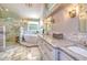 Luxurious bathroom featuring a soaking tub, glass shower, and double vanity with marble countertops at 898 Cypress Lakeview Ct, Tarpon Springs, FL 34688