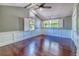 Spacious bedroom with hardwood floors, wainscoting, and multiple windows at 898 Cypress Lakeview Ct, Tarpon Springs, FL 34688