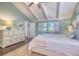 Inviting bedroom boasts vaulted ceiling, shuttered windows, and calming blue walls at 898 Cypress Lakeview Ct, Tarpon Springs, FL 34688