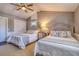 Cozy bedroom featuring two beds with gray headboards and a ceiling fan at 898 Cypress Lakeview Ct, Tarpon Springs, FL 34688