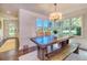 Dining room with a rustic wood table, bench seating, and large windows providing natural light at 898 Cypress Lakeview Ct, Tarpon Springs, FL 34688