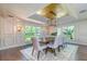 Elegant dining room with a gold coffered ceiling, modern chandelier, and many large windows at 898 Cypress Lakeview Ct, Tarpon Springs, FL 34688