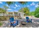 Outdoor fire pit with stone surround, chairs, and landscaping, perfect for entertaining at 898 Cypress Lakeview Ct, Tarpon Springs, FL 34688