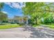 Charming home showcasing lush landscaping, mature trees, and a welcoming stone-accented entryway at 898 Cypress Lakeview Ct, Tarpon Springs, FL 34688