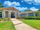 Inviting home featuring a stone facade, a covered porch with white columns, and manicured landscaping at 898 Cypress Lakeview Ct, Tarpon Springs, FL 34688