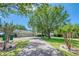 Spacious home featuring a long driveway and a two-car garage, surrounded by lush trees and greenery at 898 Cypress Lakeview Ct, Tarpon Springs, FL 34688