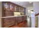 Hallway with dark wood floor, granite-topped dark wood cabinet and drawers with leaded glass doors at 898 Cypress Lakeview Ct, Tarpon Springs, FL 34688