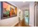 Hallway with rich wood floors, large artwork, and a doorway to the exterior at 898 Cypress Lakeview Ct, Tarpon Springs, FL 34688