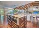 Open kitchen with double islands, stainless appliances, hardwood flooring and stone fireplace beyond at 898 Cypress Lakeview Ct, Tarpon Springs, FL 34688
