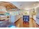 Bright, open kitchen and living space with island, stone fireplace, hardwood floors, and beamed ceilings at 898 Cypress Lakeview Ct, Tarpon Springs, FL 34688