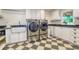 Well-equipped laundry room with a washer, dryer, sink, and black and white checkered flooring at 898 Cypress Lakeview Ct, Tarpon Springs, FL 34688