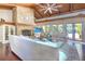 Inviting living room showcasing a stone fireplace, wood beam ceilings, and plush seating at 898 Cypress Lakeview Ct, Tarpon Springs, FL 34688