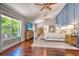 Spacious main bedroom with hardwood floors, TV, and large windows overlooking a pool at 898 Cypress Lakeview Ct, Tarpon Springs, FL 34688