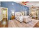 Large main bedroom with a blue accent wall, hardwood floors, and ensuite bathroom at 898 Cypress Lakeview Ct, Tarpon Springs, FL 34688
