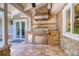The outdoor kitchen features a built-in grill, stone accents, and a stainless steel storage at 898 Cypress Lakeview Ct, Tarpon Springs, FL 34688