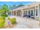The covered outdoor patio features stone floors, pillars, and an outdoor kitchen and dining area at 898 Cypress Lakeview Ct, Tarpon Springs, FL 34688