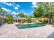 A sprawling pool area features an in-ground pool, a stone tile patio, and lush landscaping at 898 Cypress Lakeview Ct, Tarpon Springs, FL 34688