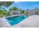 A rectangular in-ground pool surrounded by tile deck and lush landscaping create a tranquil oasis at 898 Cypress Lakeview Ct, Tarpon Springs, FL 34688