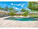 The pool is surrounded by a stone tile patio, with lush landscaping and a picturesque view at 898 Cypress Lakeview Ct, Tarpon Springs, FL 34688