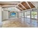 Bright sunroom with a wood-paneled ceiling, travertine floors, and sliding doors to the outdoors at 898 Cypress Lakeview Ct, Tarpon Springs, FL 34688