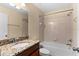 Bathroom featuring granite countertops and a tub shower combo with neutral wall tiles at 9908 Spice Bush Ct, Tampa, FL 33647