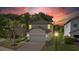 Charming two-story home with a well-manicured lawn and brick-paved driveway under a vibrant sunset at 9908 Spice Bush Ct, Tampa, FL 33647