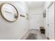 Inviting entryway with neutral tile, a round mirror, and storage bench at 10687 Lake Montauk Dr, Riverview, FL 33578