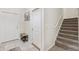 Inviting entryway featuring neutral tile flooring, a convenient coat rack, and stairs to the upper level at 10687 Lake Montauk Dr, Riverview, FL 33578