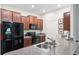 Stylish kitchen featuring dark wood cabinets, granite countertops, and modern black appliances at 10687 Lake Montauk Dr, Riverview, FL 33578