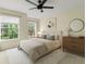 Bright bedroom featuring neutral tones, a ceiling fan, and natural light from two windows at 10807 Keys Gate Dr, Riverview, FL 33579