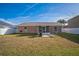 Large fenced backyard with a screened porch, chairs, and grill at 10841 Standing Stone Dr, Wimauma, FL 33598