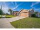 Attractive single-Gathering home with a well-manicured lawn and attached two-car garage on a sunny day at 10841 Standing Stone Dr, Wimauma, FL 33598