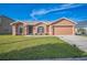 Charming single-story home features a manicured lawn, arched windows and a two-car garage at 10841 Standing Stone Dr, Wimauma, FL 33598