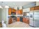Well-lit kitchen with wood cabinets, stainless steel appliances, and tile backsplash at 10841 Standing Stone Dr, Wimauma, FL 33598
