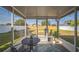 Screened in patio with a table and chairs, overlooking the backyard at 10841 Standing Stone Dr, Wimauma, FL 33598